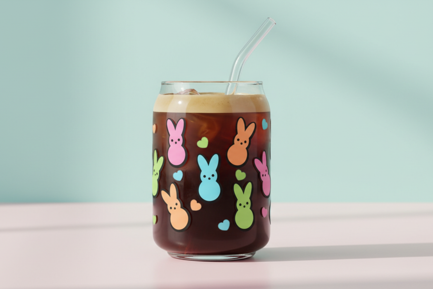 Glass of iced coffee with colorful bunny designs on a light blue background