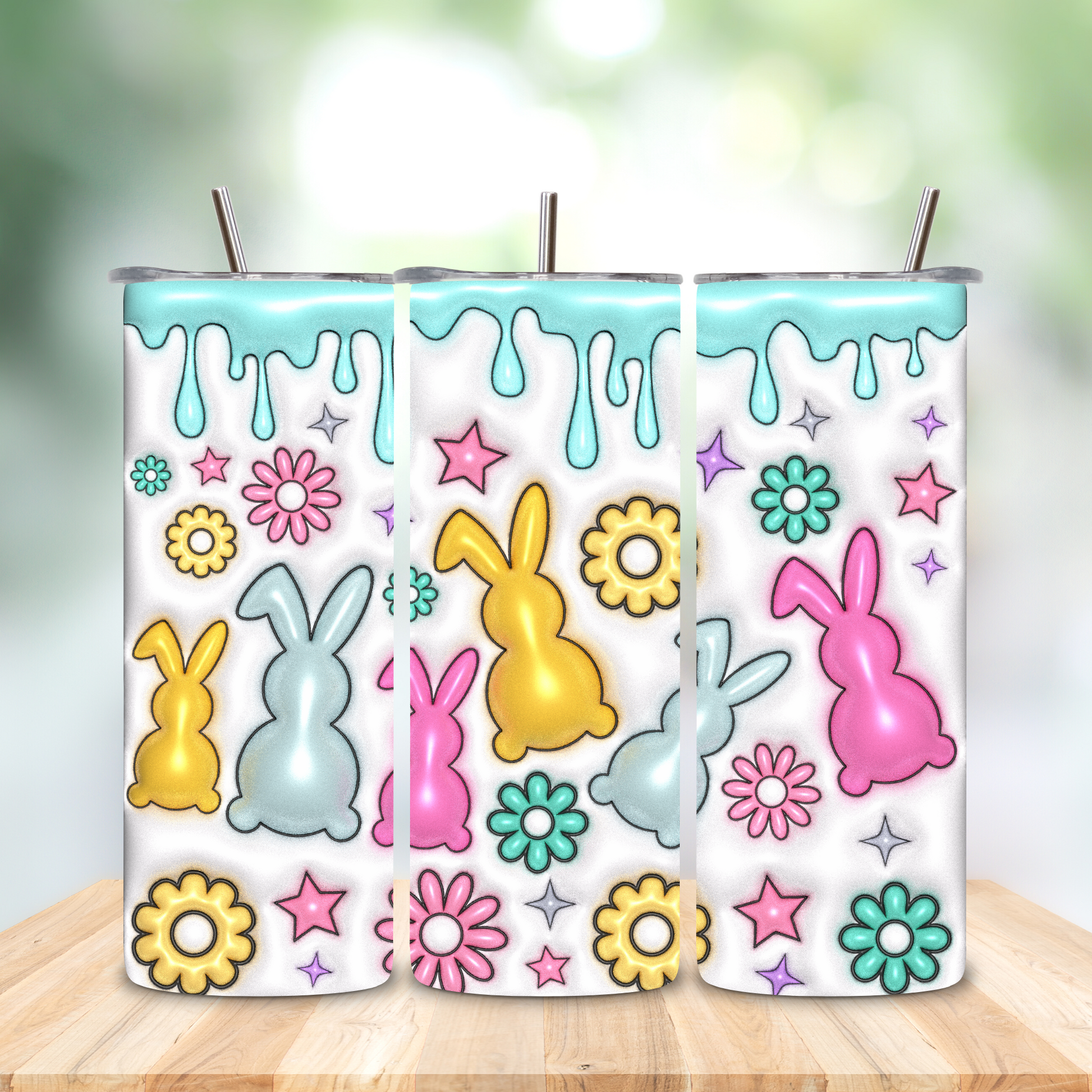 Two colorful tumbler designs with bunnies and flowers on a wooden surface.